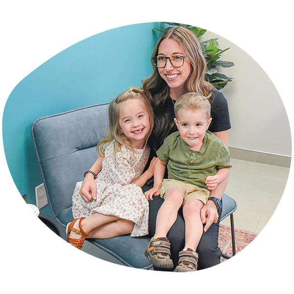 a woman holding two young children on her lap.